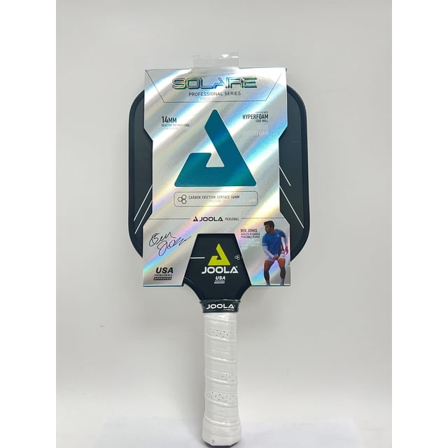 Joola Solaire CFS 14mm Ben Johns Pickleball Palette avec Poignée en Carbone Puissante Exposée dans l'Emballage. Caractéristiques Incluant une Surface à Friction en Carbone pour une Rotation Accrue, un Noyau en Polymère en Nid d'Abeille Réactif pour une Puissance et un Contrôle Équilibrés, et une Technologie de Paroi Bord Hyper-Mousse pour une performance Bord à Bord. la Palette a une Longueur de 16 Pouces, une Largeur de 8 Pouces et une Poignée Allongée à Prise Sûre de 5.5 Pouces. Approuvée par l'USAPA pour