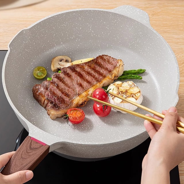 EGNMCR Kitchen Utensils Set, Non Stick Ceramic Frying Pan with Lid in beige, featuring a flat bottom and a heat-resistant handle with a wood-like texture. The pan is induction compatible and ideal for frying, sautéing, and stewing. The image shows the pan cooking a steak, cherry tomatoes, garlic, and asparagus on an induction cooktop. Its non-stick surface ensures even heat distribution and easy cleaning.