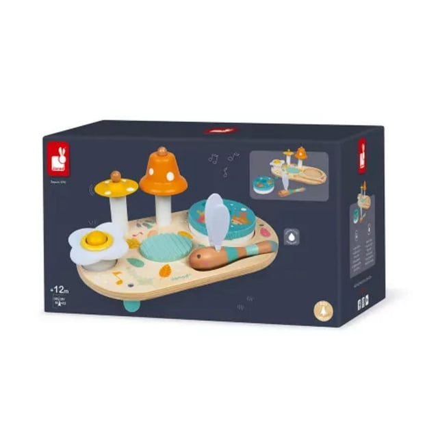Janod - Pure - Musical Table - Colourful Development Toy for babies 12 months and up, with a wooden base featuring nature-themed prints, yellow mushroom cymbal, orange spotted bell, wooden scraper, daisy-shaped squeaker, and removable tambourine showing a pond scene, played using a dragonfly-shaped stick with white felt wings, supporting early music discovery and motor skills.