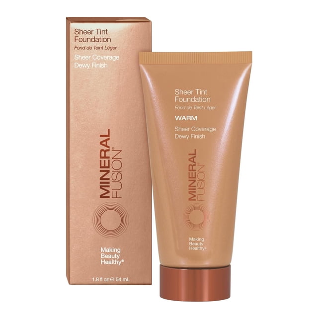 Mineral Fusion Fond de Teint Teint Transparent Fond de Teint Liquide à Teinte Chaude, 1,8 fl oz (54 ml), Montré avec Sa Boîte Assortie. le tube beige avec Capuchon en Cuivre Présente une Couvrance Transparente et un Texte de Fini Rosé, Mettant en Valeur une Formule Légère et Hydratante Qui Favorise une Peau Naturelle et Saine avec une Teinte Subtile et des Bienfaits Antioxydants.