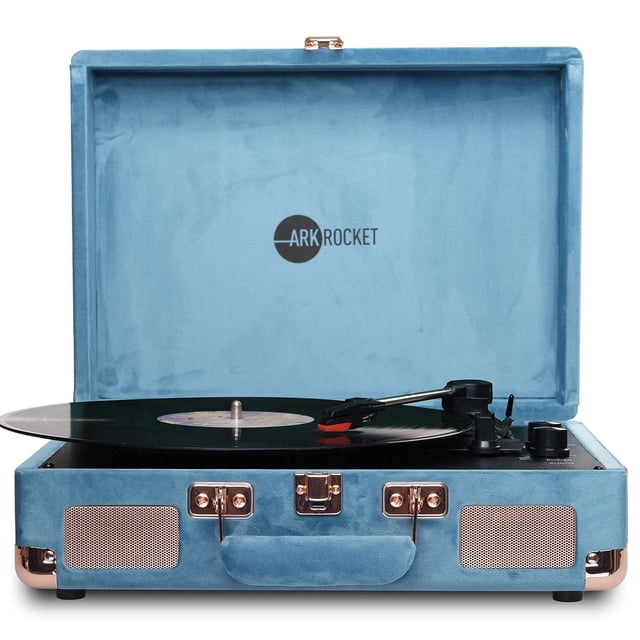 Arkrocket Curiosity Suitcase Bluetooth Turntable Vintage 3-Speed Record Player with Built-in Speakers in Blue Velvet. Features a three-speed turntable supporting 33 1/3, 45, and 78 RPM for vinyl playback, built-in Bluetooth for wireless music streaming, and integrated stereo speakers for clear sound. Portable suitcase design with carry handle, RCA Aux-in, headphone jack, and manual or auto stop switch. Ideal for retro music enthusiasts and portable audio setups.