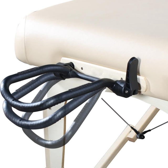 Master Massage Simplicity Table de Massage Réglable Berceau pour le Visage en Gros Plan sur le Côté Fixé à une Table de Massage beige. Il Présente un Cadre Noir flexible à Double Boucle avec angle et Hauteur Réglables, Monté sur une base en Bois Clair avec un Levier de Verrouillage Noir. Conçu pour s'Adapter à la Plupart des tables de Massage avec un Espacement des Goujons de 8 Pouces et Réduire la Pression sur le Front et les Pommettes pour le Confort du client.