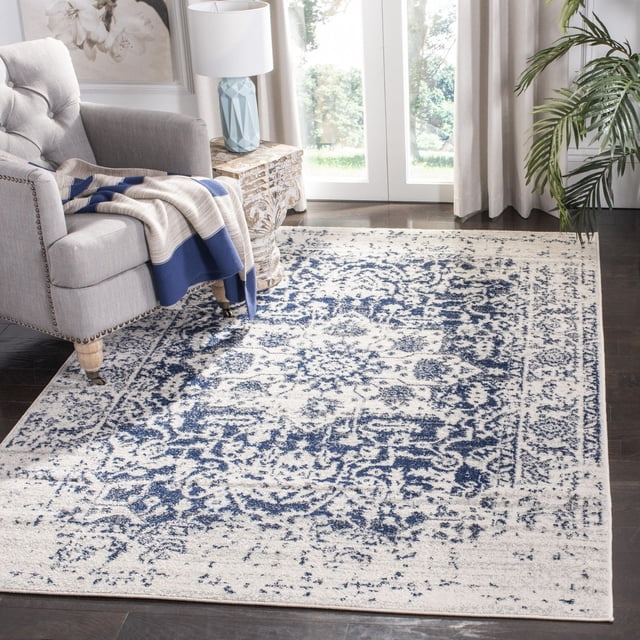 Safavieh Madison Katina Traditional Faded Area Rug with a blue and cream faded floral pattern, power loomed for durability and easy care, placed on dark hardwood floors beside a grey armchair with a blue and beige throw, near a carved wooden side table with a blue geometric lamp, in a bright room with white curtains and a green plant, ideal for enhancing transitional home decor.
