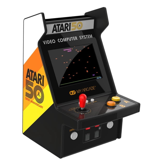 Atari Réplique de machine de Jeu d'Arcade Rétro du 50e Anniversaire avec Boîtier Noir et Panneaux Latéraux Dégradé Jaune-Orange, avec un joystick Rouge, Deux Boutons Ronds Étiquetés a et B, et un Écran Affichant le Jeu Pixélisé sur un Système Informatique Vidéo.
