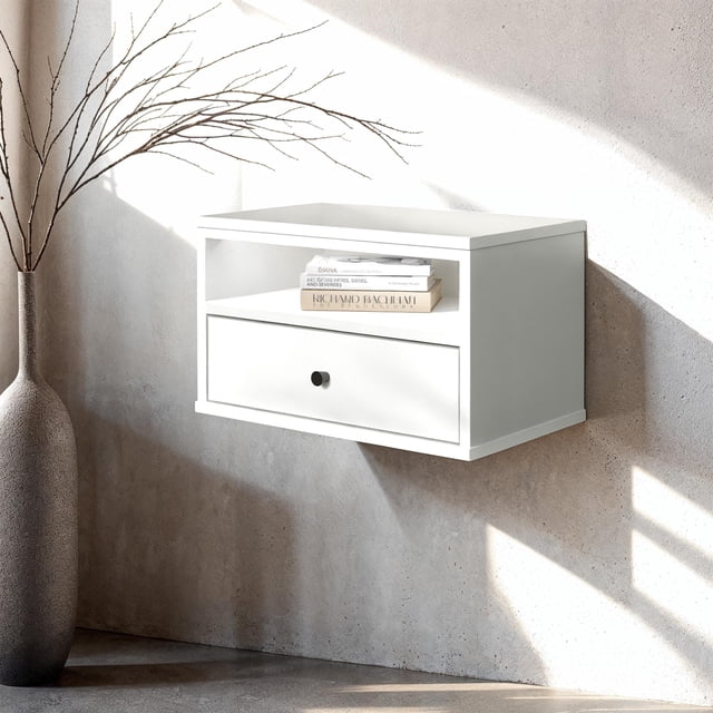 South Shore Essence Table d'Appoint Flottante à DEL en Blanc Pur, Murale avec une Tablette Supérieure Ouverte avec Éclairage DEL Intégré Tenant des Livres Empilés et un Tiroir Inférieur avec une Poignée Ronde en Métal Noir, Installée sur un Mur Texturé Gris Pâle à Côté d'Un Grand vase Texturé avec des branches Nues, Convient aux Entrées Ou aux Petits Espaces de Vie.