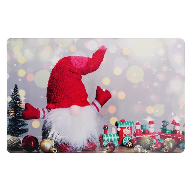 Christmas Plastic Placemat Gnome With Train - Set of 12 featuring a rectangular plastic placemat with a red-hatted gnome with white beard, a green and red toy train, and assorted Christmas ornaments on a soft bokeh background, suitable for festive dining table decor.