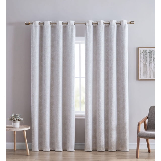 Jacquard Leaf Blackout Grommet Single Window Panel in light neutral colour with textured leaf pattern and blackout lining for privacy, hanging on a metal rod with grommet top in a minimalist room with light wood floor, small round table with plant, and gray upholstered chair.