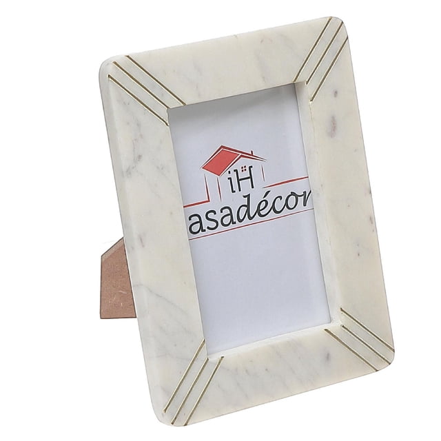 Cadre photo 4X6 en Marbre Blanc avec Incrustation de Laiton, Présentant un Cadre Rectangulaire en Marbre Blanc avec des Veinures Gris Naturelles et des accents d'Incrustation de Laiton à Chaque Coin, Conçu pour Contenir des photos de 4 X 6 Pouces, Debout sur un Chevalet Brun, Idéal pour une Déco Intérieure Élégante et l'Affichage de photos.