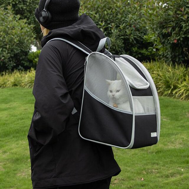 Portable Cats Carrier Bag Tote Comfortable, Handles, Handbag, Adjustable, Large shown as a black and gray pet backpack with mesh ventilation panels on three sides, worn by a person outdoors. Made of durable oxford cloth, it features adjustable shoulder straps and handles for versatile carrying options, ideal for travel or hiking with pets.