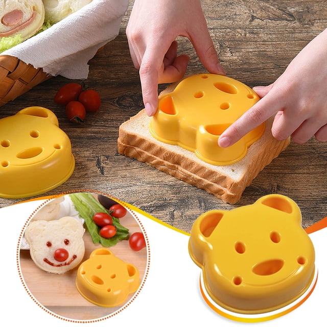 NARABB Moule à Sandwich en Forme d'Ours Bricolage pour Pain, Moule à Sushi en Forme de Boule de Riz de Couleur Jaune Vif. l'Image Met en Valeur le Moule Utilisé pour Presser un Visage d'Ours sur une Tranche de Pain, avec un Sandwich Fini Indiqué à Proximité. Cet Ensemble Comprend Quatre Formes - Ours, Cœur, Étoile et Rond - Fabriqué en Acier Inoxydable de Qualité Alimentaire et en Plastique Sans BPA. Il Est Réutilisable, Facile à Nettoyer à la Main, et Idéal pour Créer des Repas Amusants et Personnalisables pour les Enfants.