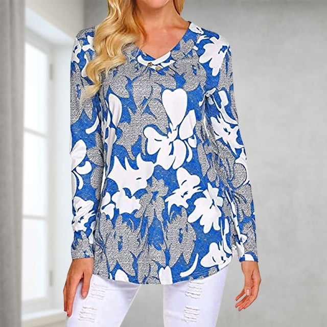 TIMIFIS Haut Tunique à Manches Longues d'Automne pour Femmes pour Porter avec des leggings, avec un design Décontracté à Col en V et une Coupe Ample. la blouse Est Présentée dans un Imprimé floral Bleu et Blanc vibrant, Faite d'Un Matériau polyester Doux Convenant à Toutes les Saisons. Idéal pour une Tenue Décontractée, la Mode d'Automne et à Agencer avec des leggings. le Modèle Porte la blouse dans un Décor Intérieur Éclatant avec un Pantalon Blanc.