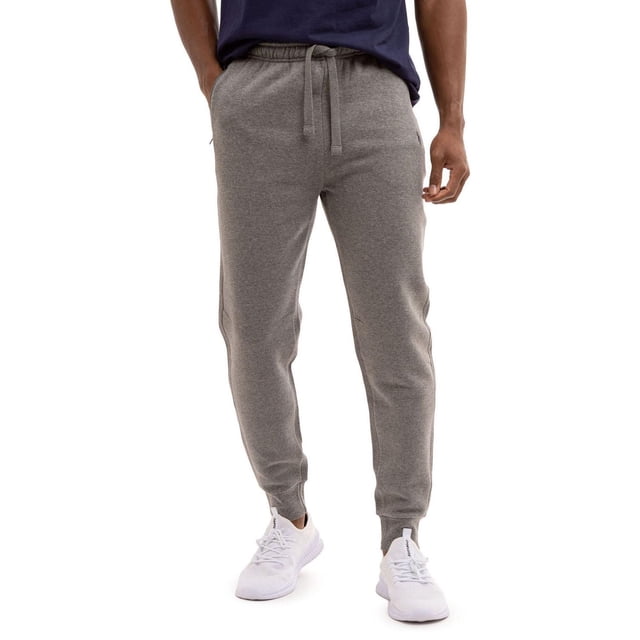 U.S. Polo Assn Jogger en Molleton Gris avec Taille Élastique et Poignets aux Chevilles, Offrant une Coupe Décontractée Idéale pour Se Détendre, des Entraînements Légers Ou Faire des Courses par Temps Froid, Montré à l'Avant sur un Modèle Portant des Espadrilles Blanches et un Chandail Bleu Marine.