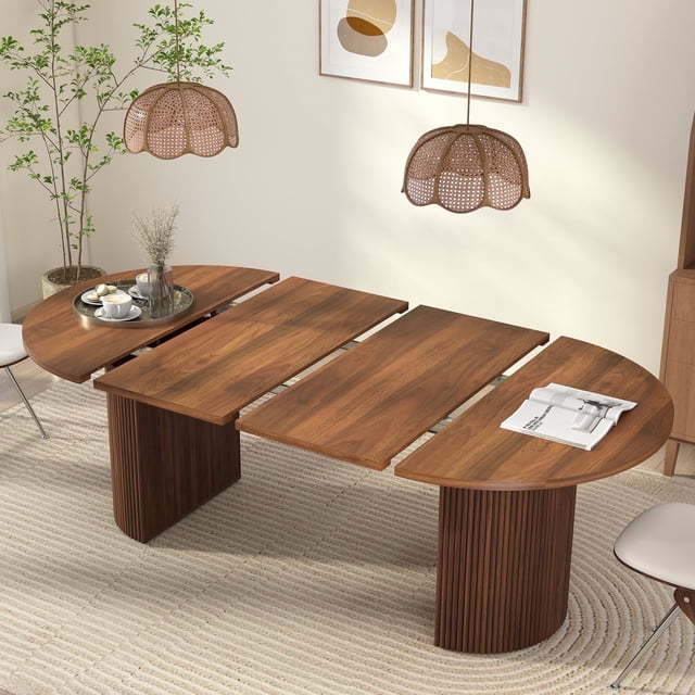 Weselon 78-inch extendable dining table with a modern oval design, crafted from walnut solid wood and supported by Roman column-style legs. The table is shown in its extended configuration, ideal for dining rooms or kitchens, accommodating 6-8 people. Features include smooth sliding tracks and a secure locking mechanism. Suitable for hosting gatherings or as a workspace. The setting includes a neutral-toned dining room with pendant lighting and decorative plants.