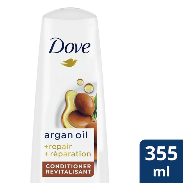 Dove Argan Oil + Repair Revitalisant en Bouteille Blanche de 355 ml avec Bouchon à Clapet, Mettant en Vedette le logo Dove et des Noix d'Argan avec des Gouttes d'Huile sur l'Étiquette, Formulé pour Nourrir et Réparer les Cheveux Abîmés pour une Douceur et une Gérabilité.