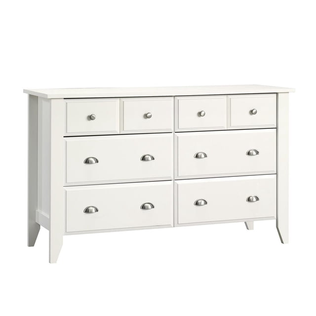 Sauder Shoal Creek Dresser in white finish with six storage drawers, featuring four deep lower drawers with metal cup handles and two smaller upper drawers with round knobs, ideal for bedroom furniture storage and organization.