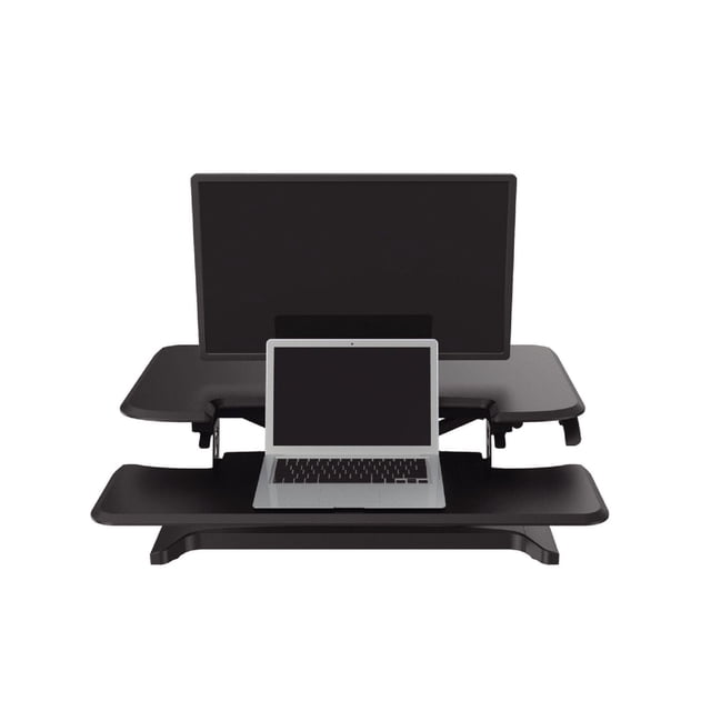 TygerClaw Sit-Stand Desktop Workstation in black with a two-tier ergonomic design featuring a wide upper surface for a monitor and a lower keyboard tray holding a laptop, adjustable from 4 to 19 inches high and supporting up to 33 lbs for easy sit-stand transitions.
