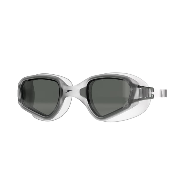 Speedo Mariner Adult Swim Goggle with front-facing larger curved dark lenses for expanded vision and UV protection. Features a translucent grey soft uni-body frame, silicone strap with side clip adjuster for comfort and fit, ideal for pool, lake, or beach use with anti-fog lenses. Also suitable for recreational water sports requiring clear underwater vision.