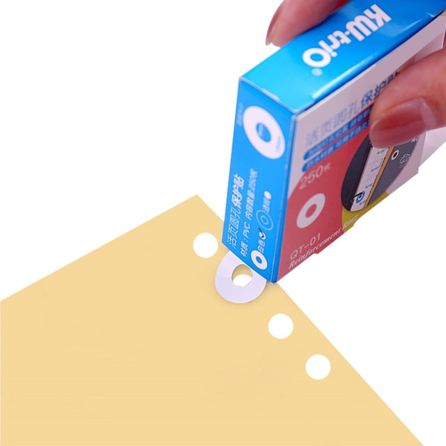 Autocollants de Renforcement de Trous pour pages Perforées, Présentés dans une Boîte Étiquetée avec 250 Étiquettes. une Main Distribue un Autocollant Autocollant en PVC Blanc sur un Trou de Papier à Feuilles Mobiles. les Autocollants Ont un Diamètre Intérieur de 6 mm et un Diamètre Extérieur de 15 mm, Conçus pour Réparer et Renforcer les Trous Perforés. Convient aux Trous de Classement, aux albums photo DIY et au Marquage de Cahier.