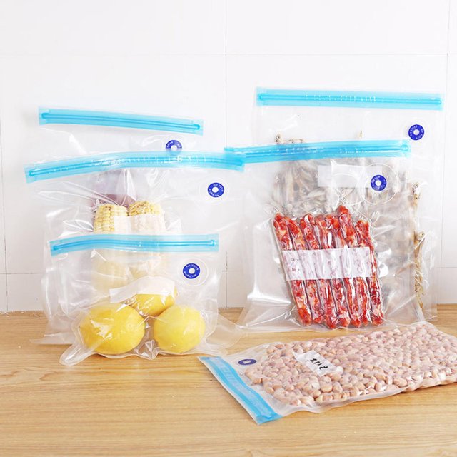 10 Sacs sous Vide Réutilisables, Sacs de Rangement Alimentaires sous Vide Réutilisables, Sacs de Rangement pour Scelleuse sous Vide, Sans BPA. l'Image Affiche des Sacs Transparents Scellés sous Vide avec Fermetures à double Glissière Bleues, Contenant des Aliments comme du Maïs, des Citrons, des Noix et des Viandes Séchées. Faits de Matériaux PA et PE, Ces Sacs Aident à Garder les Aliments Frais de 3 à 5 Fois Plus Longtemps. Ils Comportent une valve pour une Mise sous Vide Facile et Conviennent à l'Entreposage d'Aliments Solides et Semi-Solides