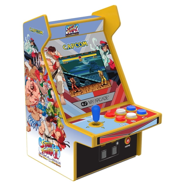 MICRO PLAYER™ 6.75" PRO - Super Street Fighter II: The New Challengers mini arcade console with yellow trim and blue joystick, featuring a 2.75" full-color display showing classic fighting game action, six red, white, and blue buttons labeled A, B, C, and side artwork of iconic Street Fighter II characters, ideal for retro arcade gaming enthusiasts.