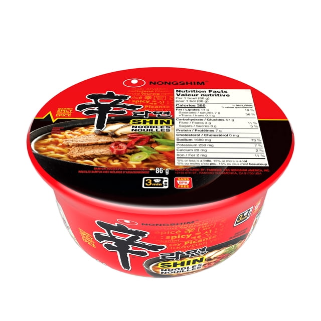 Nongshim Spicy Shin Bowl Noodle Soup in a red recyclable bowl with black and yellow label showing spicy beef broth with noodles, beef slices, and vegetables, nutrition facts on the lid, 86 grams, microwaveable in 3 minutes, BPA free, ideal for quick instant soup meals.