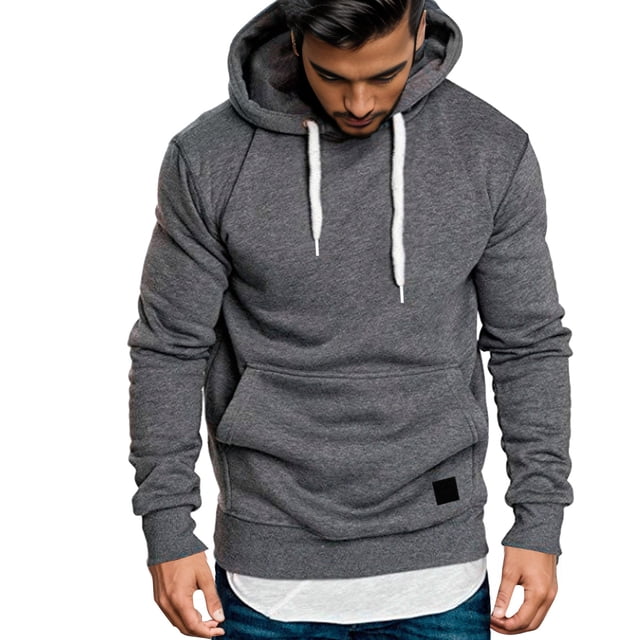 2025 Chandails à Capuchon et Chandails pour Hommes Chandail à Capuchon Décontracté pour Hommes à Empiècements Chandail à Capuchon Mignon Chandail Grande Taille. Vue Frontale d'Un Chandail à Capuchon Décontracté pour Hommes de Couleur Gris Foncé avec un design à Empiècements. le Chandail à Capuchon Présente une Capuche à Cordon, des Manches Longues et une Poche Kangourou. Fait de Coton, Il Convient à Toutes les Saisons et Idéal pour le Port Quotidien, le Travail Ou les Sorties Décontractées. le Modèle l'Agence avec un Chandail de Dessous Blanc et des jeans Bleus.
