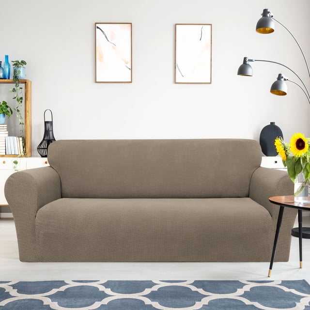 PiccoCasa Stretch Sofa Slipcover in coffee color, designed for medium-sized sofas. Made from 95% polyester and 5% spandex, this washable furniture cover features a textured, elastic fit with foam strips for secure placement. Suitable for protecting sofas from pets, including dogs, and rejuvenating worn furniture.