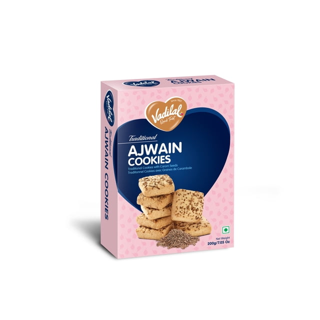Vadilal Ajwain Cookies box showing traditional Indian biscuits topped with carom seeds, stacked with loose seeds in front on a pink background with a navy blue heart shape, net weight 200g/7.05 oz, suitable for enjoying as a spiced snack
