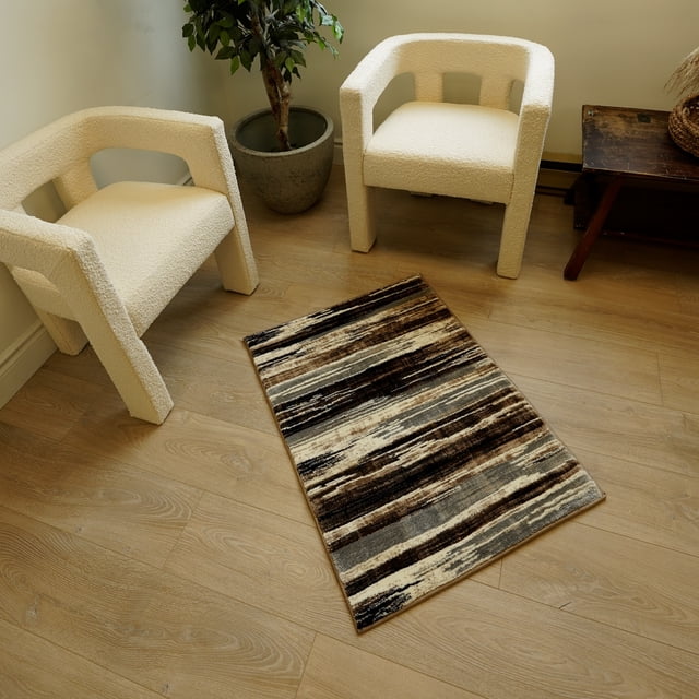 Rug Branch Montage Collection Modern Abstract Area Rug with horizontal brown, beige, and gray stripes on light wood flooring between two cream boucle armchairs, accompanied by a potted plant and wooden side table, suitable for living rooms and entryways.
