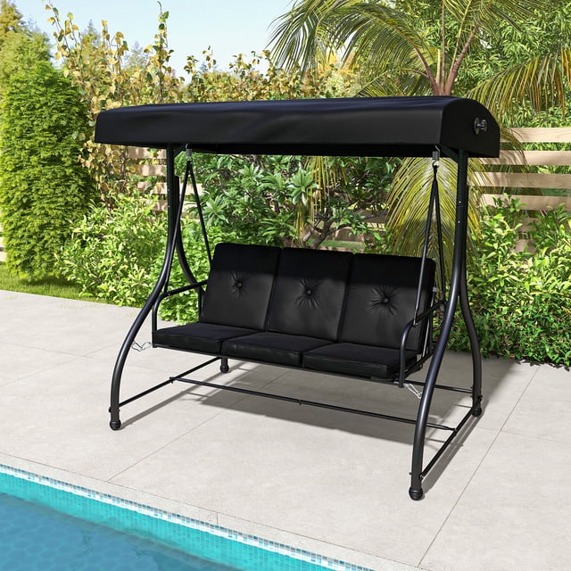 Costway Balancelle Extérieure 3 Places Convertible pour Patio Swing avec Auvent Ajustable en Noir, Conçue pour la Détente à l'Ombre dans les Jardins, patios Ou Vérandas. Comprend un Cadre Métallique Robuste, des Coussins Rembourrés et un design 2-en-1 Qui Se Convertit en Lit. Positionnée Près d'Une Piscine dans un Cadre Extérieur Luxuriant avec Verdure et Palmiers.