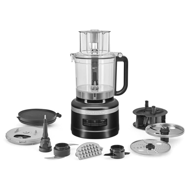 KitchenAid® Robot Culinaire de 13 Tasses avec Trousse de Découpe en Noir et Argent, Doté d'Un Bol de Travail Transparent de 13 Tasses avec Poignée Noire et Boutons de Commande sur la base. Comprend Lame Polyvalente, Disque à Trancher Ajustable, Trousse de Découpe en dés, Lame à Pâte, Disque à Râper Réversible, caddy de Rangement et Couvercle de Réfrigérateur Disposés Autour de l'Unité sur un Fond Blanc, Convient pour Hacher, Trancher, Couper en dés, Râper, Pétrir et Mélanger.
