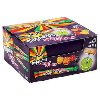 Maynards Wine Gums Candy Rolls 18 X 44 g dans une Boîte Vibrante de Marque Présentant des Saveurs Fruitées comme le Cassis, la Framboise, l'Orange et le lime. l'Emballage Met l'Accent sur la texture Moelleuse et le Charme Nostalgique de Ces Bonbons Classiques, Idéal pour le Partage Ou le Plaisir Personnel.