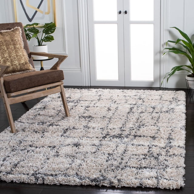 Safavieh Fontana Bayram Abstract Geometric Plush Shag Area Rug with 2-inch plush pile in neutral beige and gray tones, featuring an abstract geometric pattern on synthetic yarns, placed on dark hardwood flooring in a modern living room with a wooden armchair and green plants, suitable for enhancing comfort and style in larger spaces.