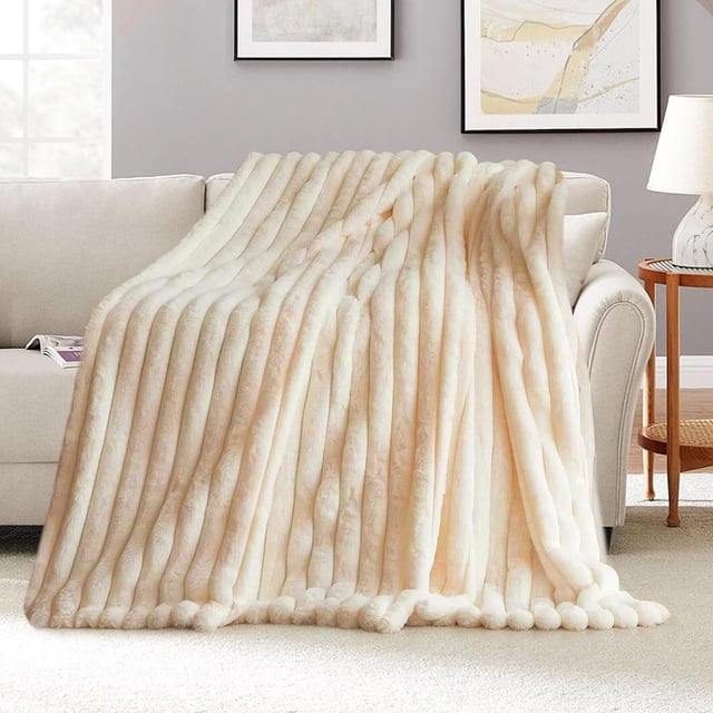 Boovnll Couverture Jetée, une Fausse Couverture super Douce et Chaude, Drapée sur un sofa de Couleur Claire dans un Décor de Salon Douillet. la Couverture Présente une texture Côtelée avec une Apparence Pelucheuse et Luxueuse, Idéale pour Ajouter de la Chaleur et du style à Votre sofa Ou Lit. le Ton Neutre Complète le Décor Moderne, Y Compris une Oeuvre Murale Encadrée et une table d'Appoint avec une Lampe. Convient pour une Utilisation sur des Canapés, des Lits Ou comme Jeté Décoratif.