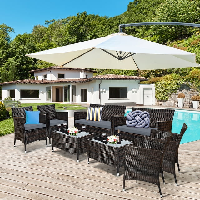 Costway 8PCS Rattan Patio Furniture Set Cushioned Sofa Chair Coffee Table Garden Grey arranged poolside. Features four single chairs, two loveseats, and two coffee tables with tempered glass tops. Grey cushions enhance the hand-woven rattan design, perfect for outdoor patio conversation sets.