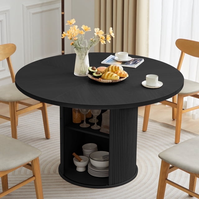Wirrytor 47-inch black dining room table with storage, featuring a round tabletop and a barrel column base with 15mm thick wooden strips. The table includes a 2-layer storage shelf within the central column, ideal for storing dining essentials. The textured black finish complements modern and industrial-inspired decor. Designed to seat 4 comfortably, the table measures 47.2 inches in diameter and 29.5 inches in height. The round metal leg in the center of the column adds stability and a contemporary touch. Shown in a dining room setting with light wood chairs and a neutral rug.