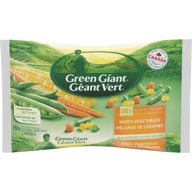 Green Giant Mixed Vegetables package displaying a blend of corn, diced carrots, sweet peas, and green beans on a green background with a Canadian farm landscape and a label stating it is grown and packed in Canada, suitable for convenient frozen vegetable meals.