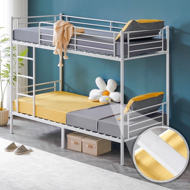 Ktaxon Upgrated Twin over Twin Bunk Bed in white, a compact metal bed frame ideal for kids' rooms, guest rooms, or shared spaces. Features include a flat step ladder with rubber covers for safe climbing, 13.7-inch high guardrails for safety, and reversible stairs for flexible installation. Supports two twin mattresses with a 400lb weight capacity per bed and offers 10.47-inch under-bed clearance for storage. Displayed in a modern room with a blue wall and decorative accents.