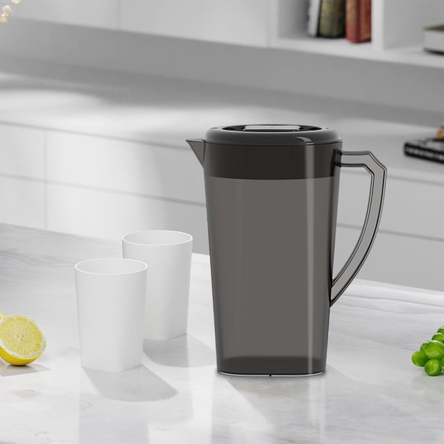 Plastic Pitchers avec Poignée et Couvercle, Grande Capacité de 3 L, Présenté dans un design Noir Épuré avec Couvercle à Rabat et Poignée Ergonomique. le Pichet Est Posé sur un Comptoir en Marbre à Côté de Deux Tasses Blanches et d'Un Citron Tranché, Idéal pour Servir des Boissons Froides comme du Thé Glacé, de la Limonade Ou des Jus. Sa Taille Compacte s'Insère Facilement dans les Portes du Frigo, le Rendant Parfait pour la Maison, les Fêtes Ou les Rassemblements.