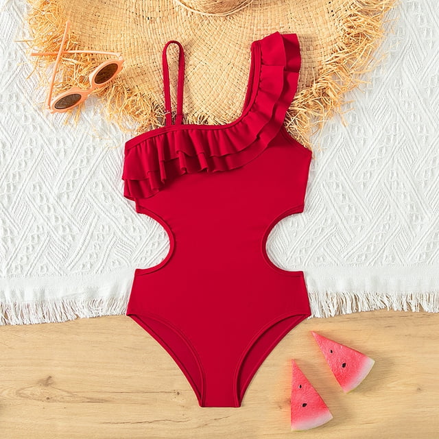 Girls Swimsuit 1 Piece Swimwear Sleeveless Ruffle Floral Pattern Bathing Suits for Girls 11-12 Years. The image features a bright red one-piece swimsuit with a ruffled one-shoulder design and side cutouts, made from lightweight, quick-drying fabric. It is styled on a white textured backdrop with a straw hat, sunglasses, and watermelon slices, suggesting a fun summer setting.