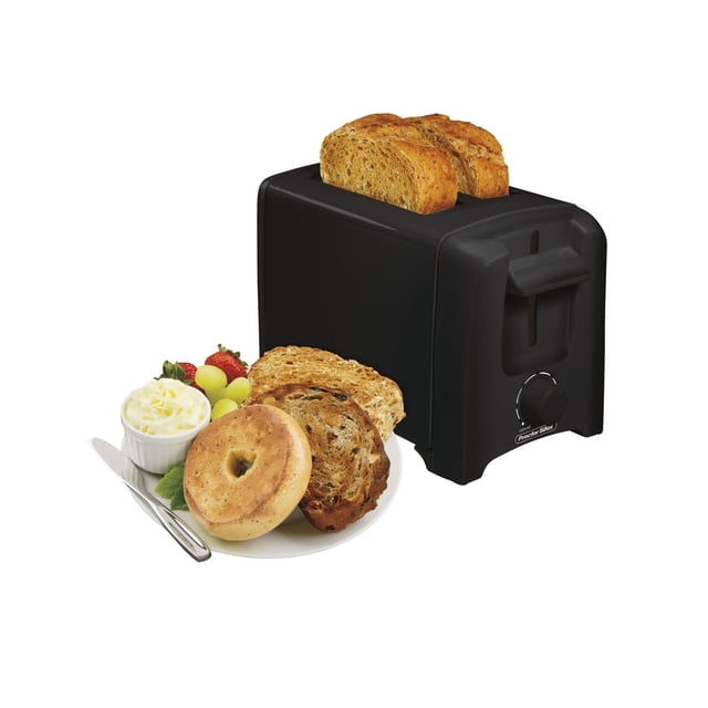 Proctor Silex 22613 Coolwall 2 Slice Toaster in black with two slices of whole wheat bread toasted inside, featuring a cool-touch exterior, rotary shade selector, auto shutoff for safety, and snap-open crumb tray, shown beside a plate with a toasted bagel, two slices of toasted bread, butter, strawberries, and grapes, suitable for quick breakfast preparation.