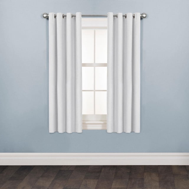 Mainstays Faux Suede Drapery Grommet Window Panel in light grey, 54 inches wide by 63 inches long, hanging on a silver metal rod over a window with white trim, set against a pale blue wall and dark wood floor, featuring soft faux suede texture and easy-install grommet rings, suitable for room darkening and decor refresh.