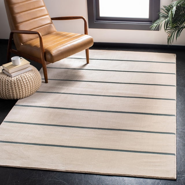 Safavieh Orwell Caelestinus Solid Striped Area Rug featuring a beige base with dark horizontal stripes, power loomed with medium cut pile synthetic yarns, displayed under a tan leather armchair and knitted pouf on dark flooring, ideal as an accent rug for contemporary home décor.