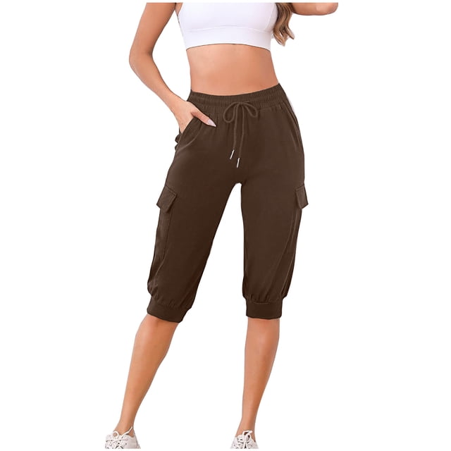 Timegard Cargo Shorts for Women Elastic High Waisted Drawstring Sweatshorts in a dark brown colour. These outdoor half pants feature a loose fit, elastic waistband with drawstring, and side pockets for added functionality. Made from 95% polyester and 5% spandex, the fabric is lightweight, breathable, and soft, ideal for casual summer wear. The model is shown wearing the shorts paired with a white cropped tank top and white sneakers, highlighting their versatility for outdoor activities or lounging.