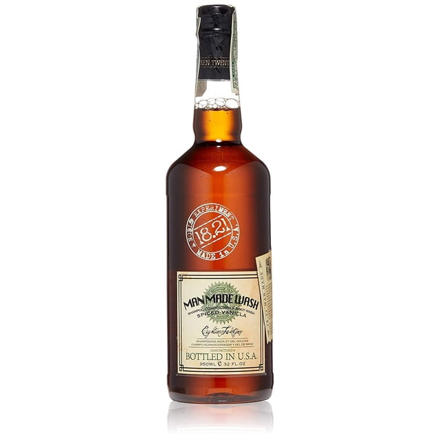 18.21 Man Made 3-in-1 Spiced Vanilla Body Wash, Shampoo and Conditioner, 32 Ounce bottle with amber-colored packaging styled like a vintage whiskey bottle. The label highlights 'Man Made Wash' and 'Spiced Vanilla,' suitable for hydrating body care and lightweight hair conditioning.
