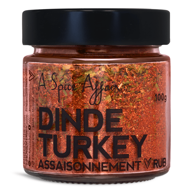 Assaisonnement pour Dinde A Spice Affair, Pot de 100 g (3,5 oz). Pot en Verre Transparent avec Couvercle Noir Contenant un Mélange vibrant d'Épices, Y Compris le paprika, l'Ail, le Poivre Noir et des Herbes comme le Basilic, l'Estragon et le Thym. l'Étiquette Présente un Texte Noir Audacieux avec le Nom de Marque « A Spice Affair » et « Assaisonnement pour Dinde » Bien en Vedette. Idéal pour Assaisonner une Dinde Rôtie, Farcie Ou Braisée