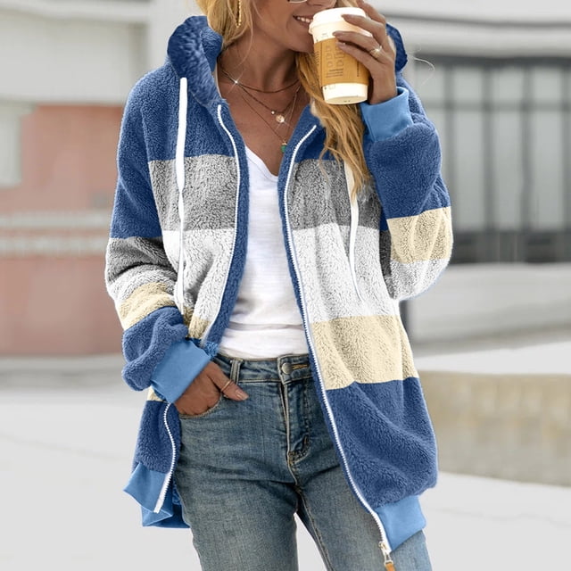 zanvin Womens Winter Fuzzy Fleece Jacket Hooded Color Block Patchwork Cardigan Drawstring Coat Oversized Outerwear with Pockets in blue. The jacket features a hood, long sleeves, and a loose fit with a color block design in shades of blue, white, and beige. Made of soft polyester fleece, it includes a drawstring closure and two front pockets. Styled casually with jeans, the jacket is suitable for daily wear, work, or casual outings during colder seasons.