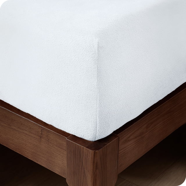 Bare Home Cozy Fleece Fitted Sheet in white, designed for king-size beds. Made from extra plush polar fleece, this deep pocket sheet fits mattresses up to 15 inches deep. The hypoallergenic material is wrinkle, fade, pill, and shrink resistant, offering lightweight breathability and moisture-wicking properties. Dimensions: 78 inches wide by 80 inches long.