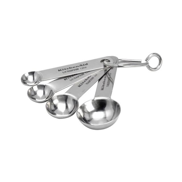 KitchenAid Stainless Steel Measuring Spoons set of five with engraved sizes 1 tablespoon, 1/2 tablespoon, 1 teaspoon, 1/2 teaspoon, and 1/4 teaspoon, made from rust-resistant stainless steel and connected by a metal ring for durable, precise kitchen measuring.