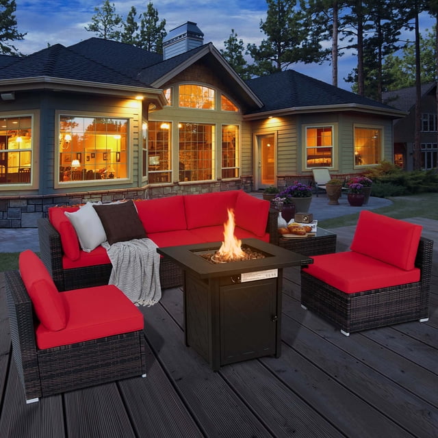 Costway 7 PCS Patio Furniture Set with 28" 50000 BTU Propane Gas Fire Pit Table Cushions Red. This outdoor set includes a mix brown PE wicker sectional sofa with red cushions, a 28-inch propane gas fire pit table, and a tempered glass coffee table. The fire pit table features adjustable flames and doubles as a coffee table with a lid. The set is arranged on a wooden deck in a backyard setting, with a cozy ambiance created by the fire pit's warm glow.